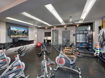 A gym with exercise equipment and a flat screen tv